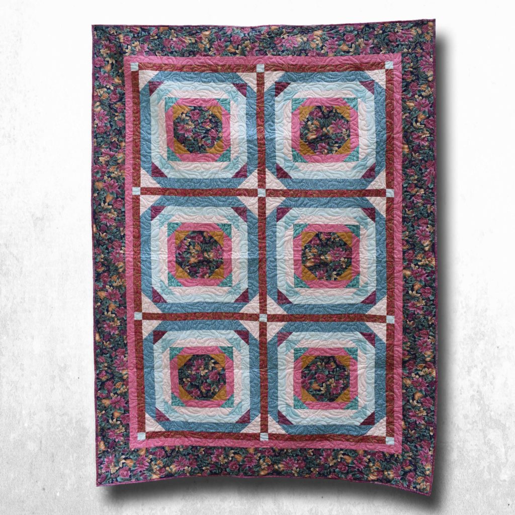 Deep rose and teal florals in traditional block pattern.