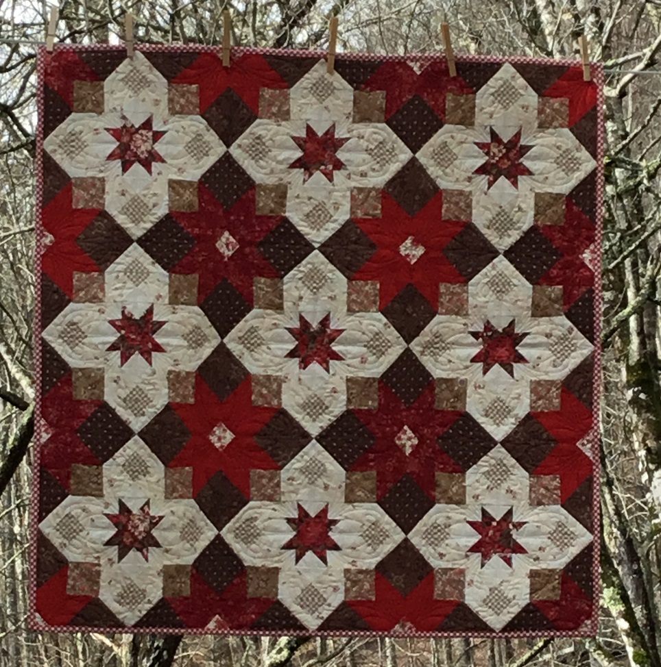 Square table topper quilt in bright red, brown and cream.