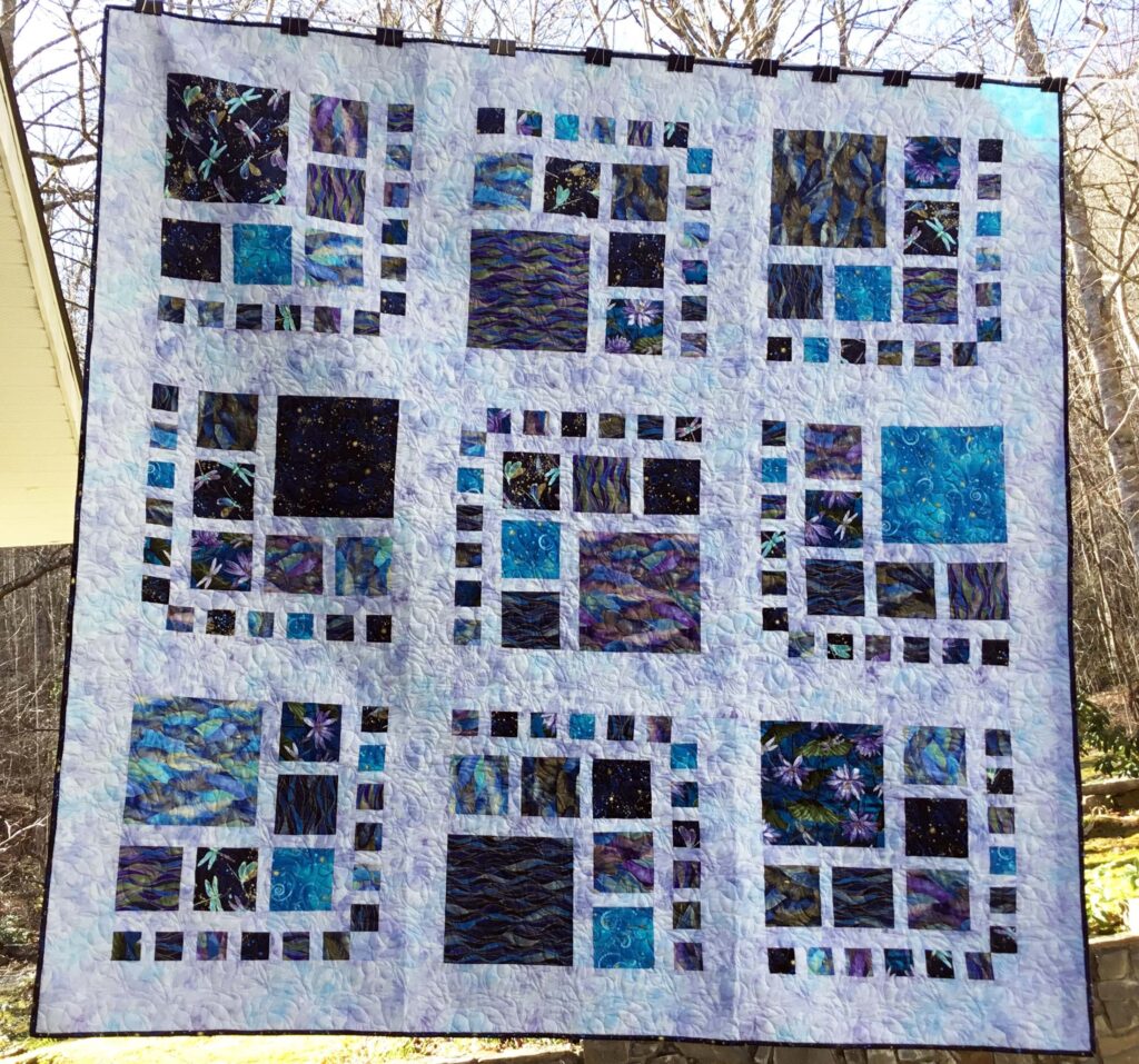 Dragonflies and lotus flowers in watercolor tones give this twin size quilt a unique softness and tranquility, featuring a modern grid-like pattern