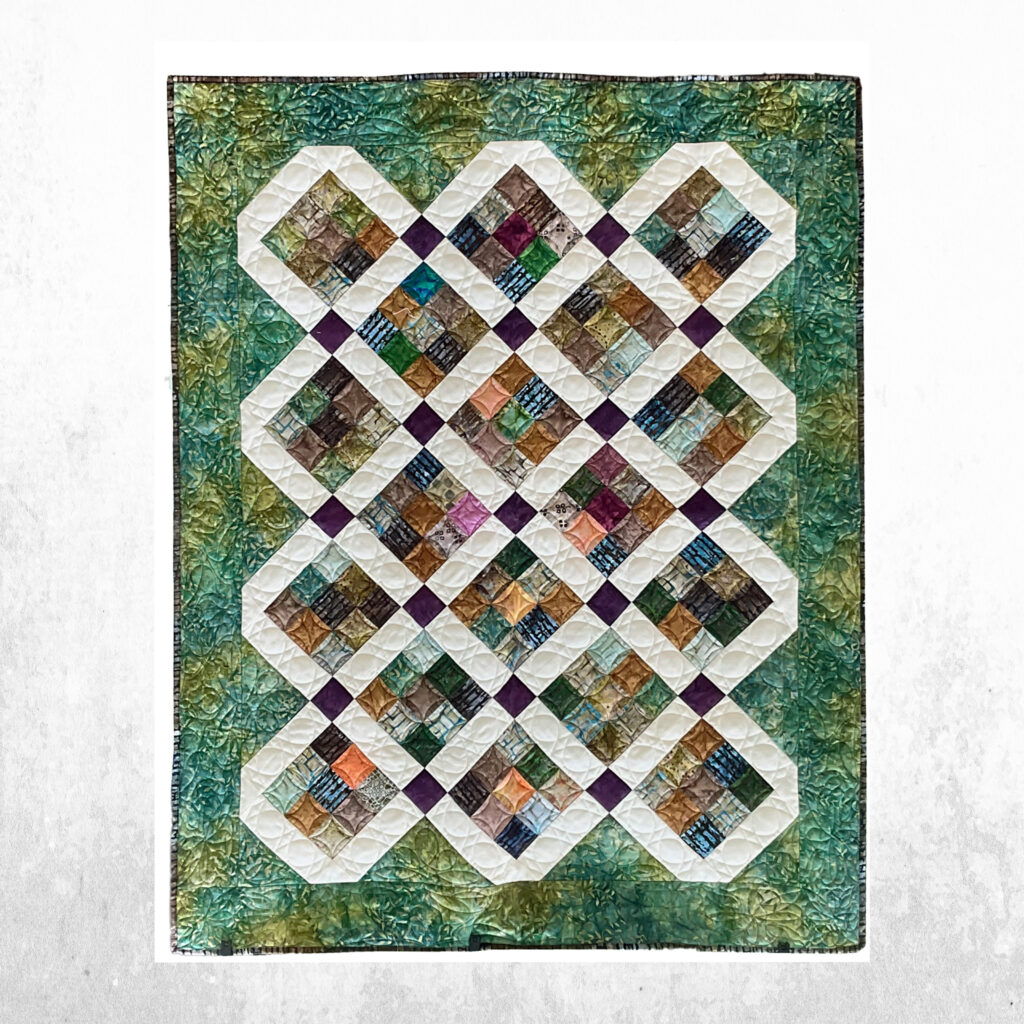 Traditional patchwork quilt features a rich tapestry of forest greens and earthy browns.