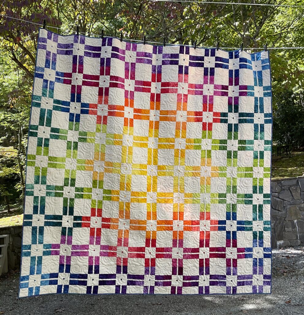 Quilt modern geometric design awash with vibrant rainbow shades.
